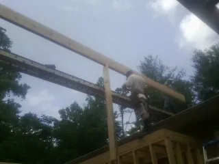 Carpenter setting a ridge beam over a new addition frame — Ice Dam Removal by Roofing Brothers in Township Of Washington